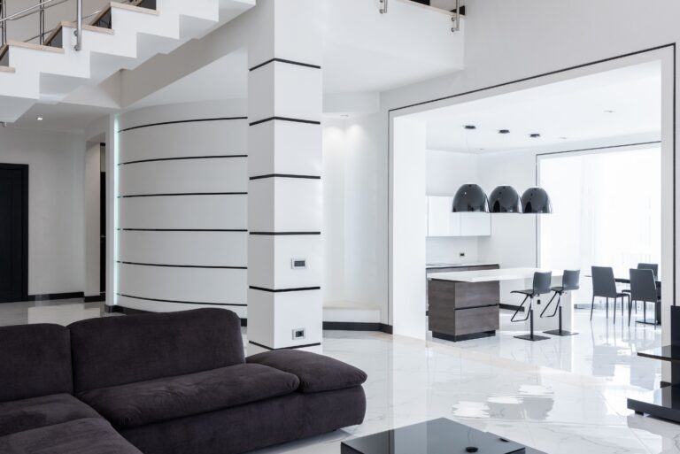Interior of minimalist contemporary mansion with spacious living room and kitchen with modern furniture in daylight