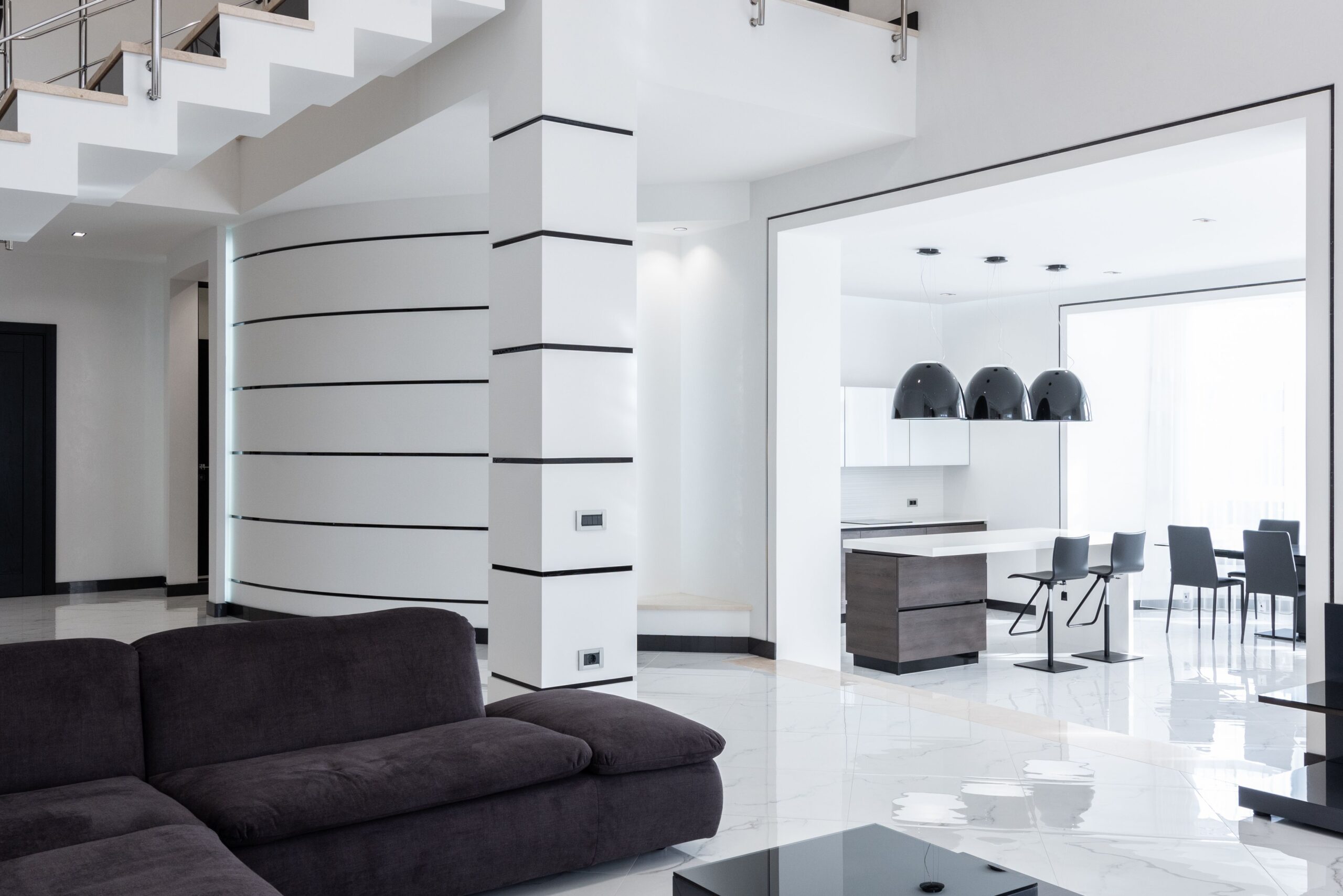 Interior of minimalist contemporary mansion with spacious living room and kitchen with modern furniture in daylight